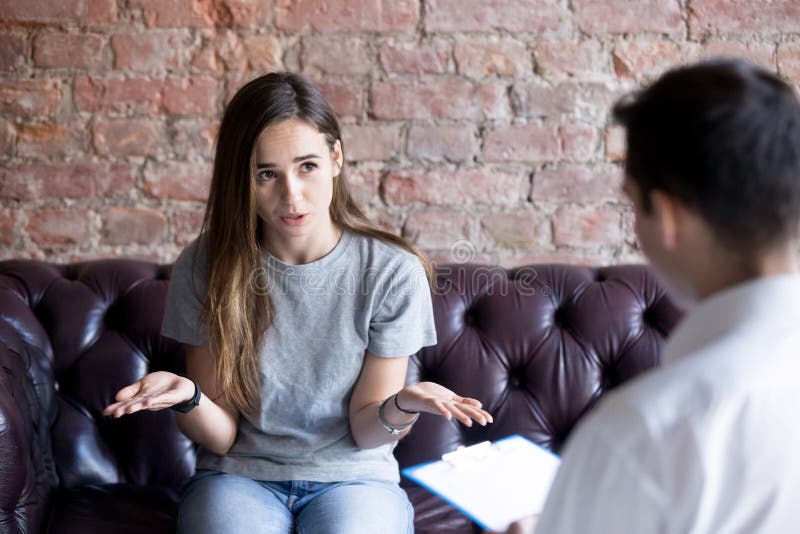 Unhappy young woman at a psychologist counselor reception. stock photo