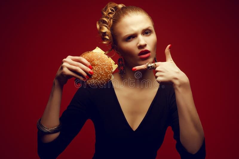 Unhealthy eating. Junk food concept. Guilty pleasure. Woman with burger. Unhealthy eating. Junk food concept. Guilty pleasure. Portrait of a fashionable model stock photo Unhealthy eating. Junk food concept. Guilty pleasure. Woman with burger. Unhealthy eating. Junk food concept. Guilty pleasure. Portrait of a fashionable model stock photo