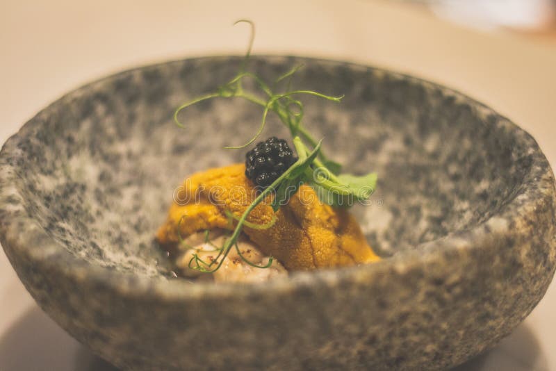 Uni and shirak and caviar japanese appetiser in a stone bowl