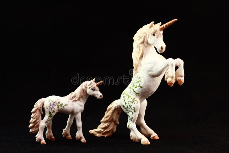 Unicorn figurine toys isolated in black background.