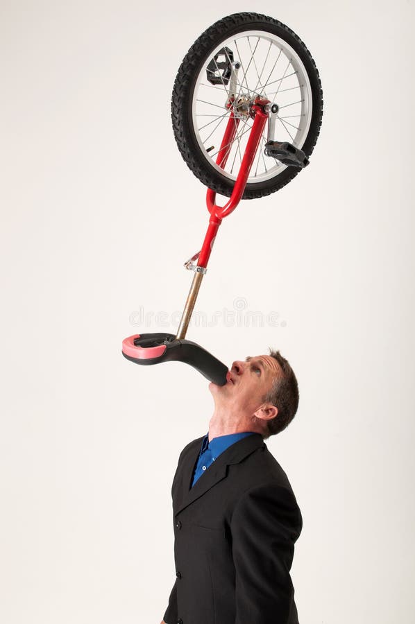 Unicycle de equilíbrio do homem de negócios imagens de stock royalty free Unicycle de equilíbrio do homem de negócios imagens de stock royalty free