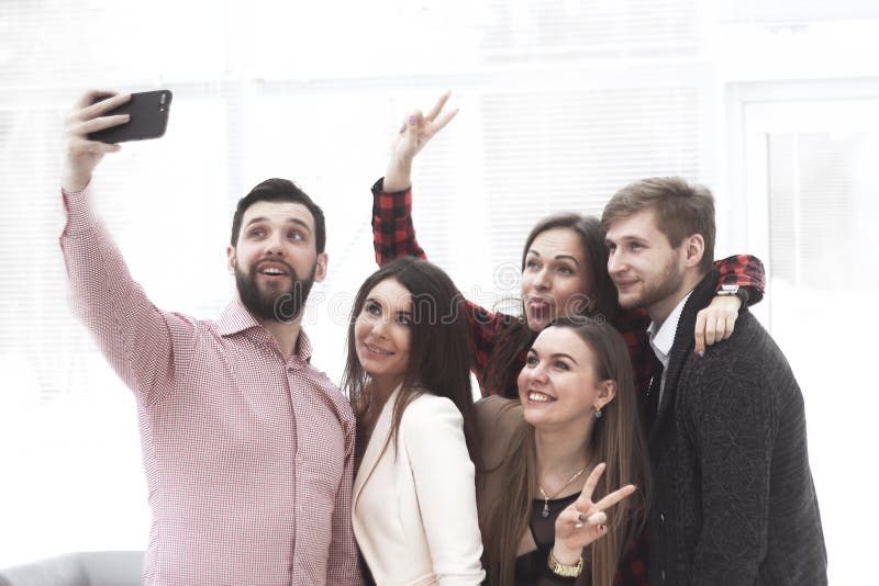 A unidade de negócio criativa toma selfies em um escritório moderno imagem de stock royalty free A unidade de negócio criativa toma selfies em um escritório moderno imagem de stock royalty free