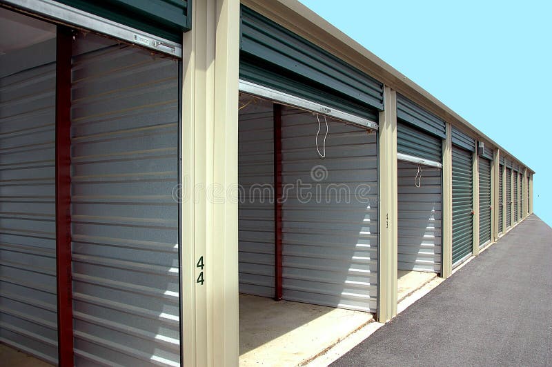 Row of self-storage warehouse units, the first three with doors open, the rest closed. Row of self-storage warehouse units, the first three with doors open, the rest closed.