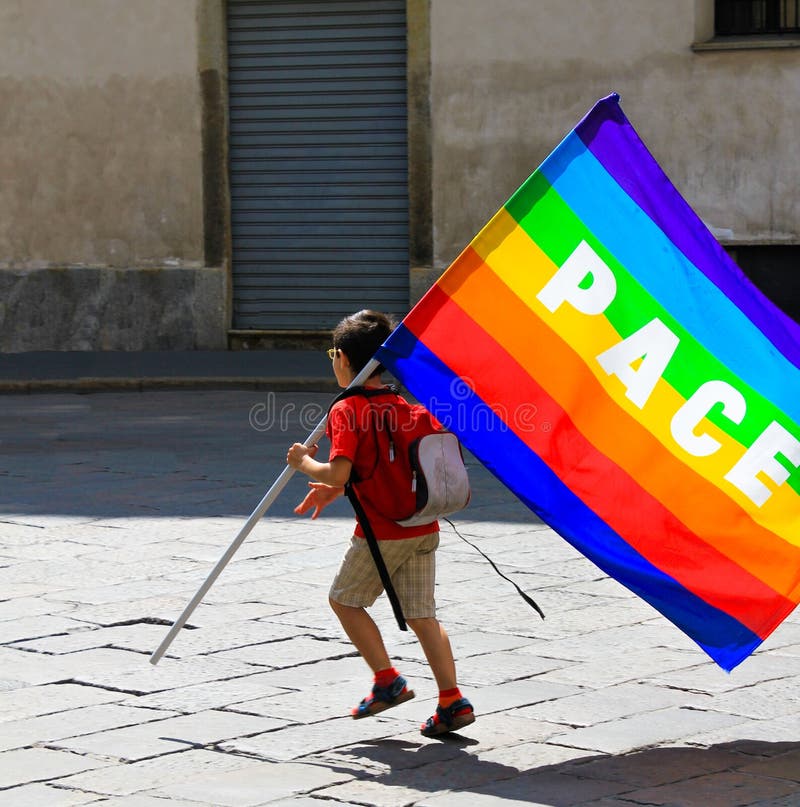 Unidentified child with rainbow flag with. `peace ` Latin and Ita...