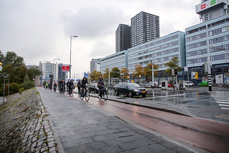 Rotterdam, the Netherlands - October 6, 2021: Unidentified group of people riding a bike in the streets of Rotterdam. Biking is the main type of transportation in the Netherlands