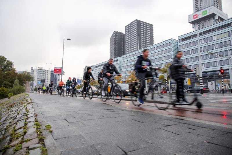 Rotterdam, the Netherlands - October 6, 2021: Unidentified group of people riding a bike in the streets of Rotterdam. Biking is the main type of transportation in the Netherlands