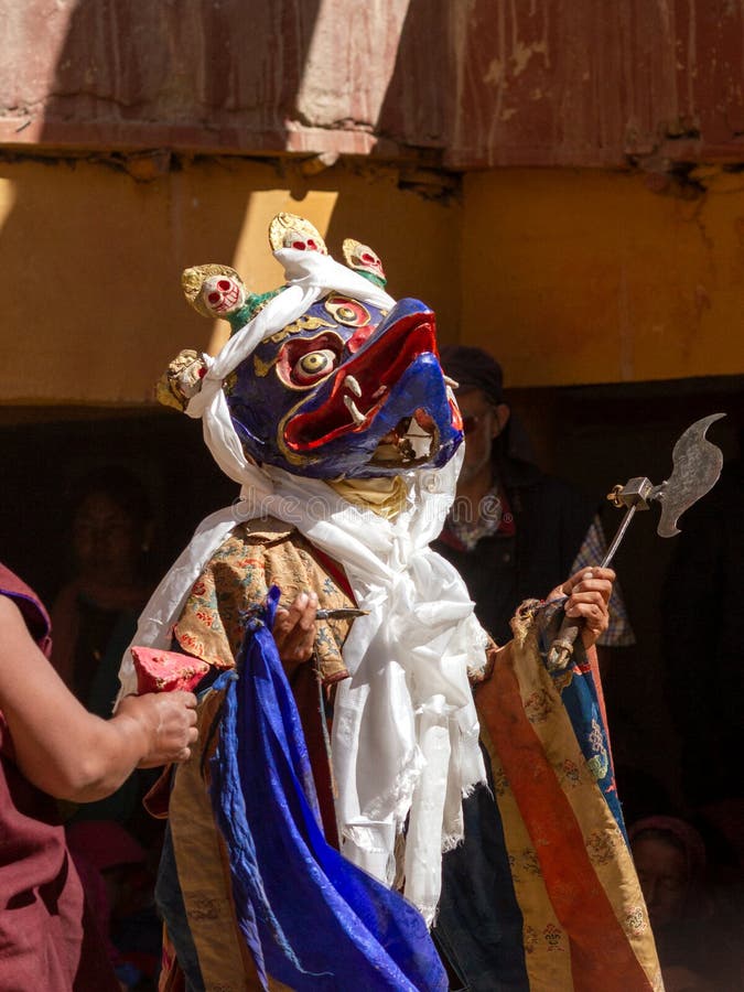 Monk in Garuda mask with ritual axe parashu or elephant goad ankusha performs religious mystery dance of Tantric Tibetan Buddh