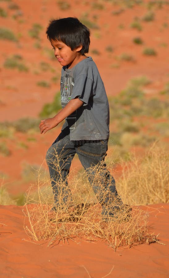 Unidentified navajo children playing in the sand of monument valley