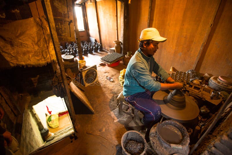 Unidentified Nepalese man working in the his pottery workshop. stock images