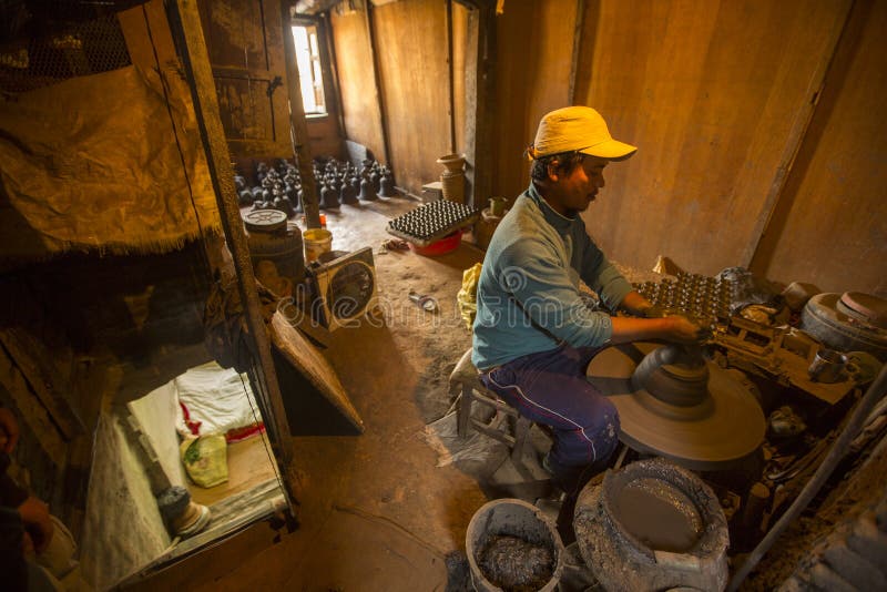 BHAKTAPUR, NEPAL - DEC 7, 2013: Unidentified Nepalese man working in the his pottery workshop. More 100 cultural groups have created an image Bhaktapur as Capital of Nepal Arts.