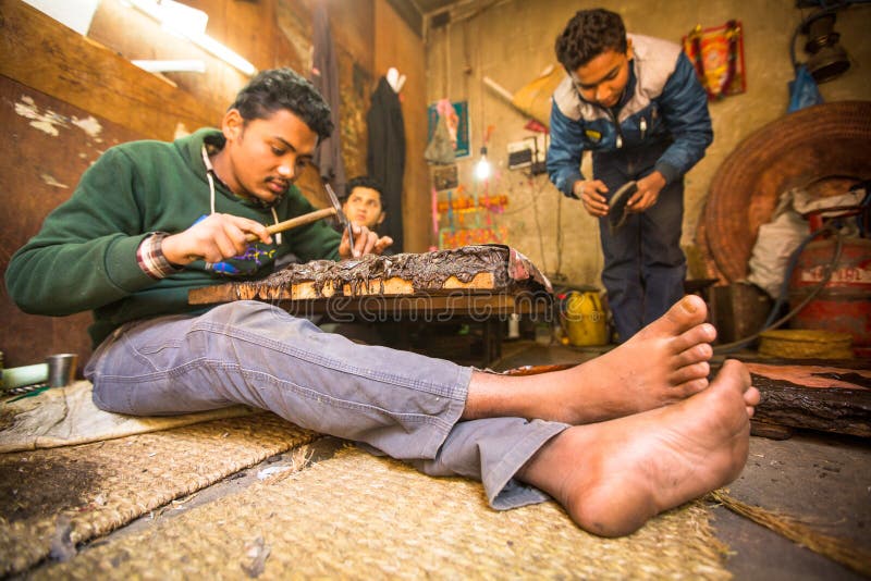 Unidentified Nepalese tinman working in the his workshop. royalty free stock photography
