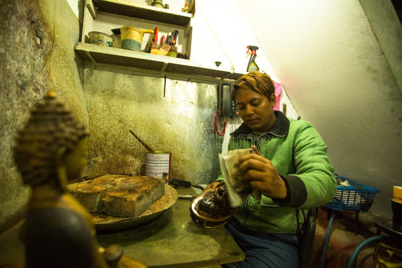 Unidentified Nepalese tinman working in the his workshop. stock images