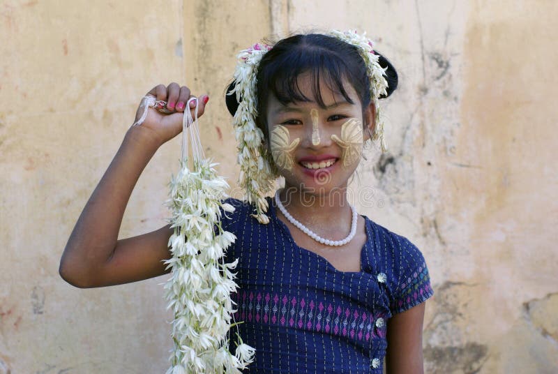 Unidentified Smiling Burmese girl with traditional thanaka on her face on January 03, 2011 in Mandalay, Myanmar.