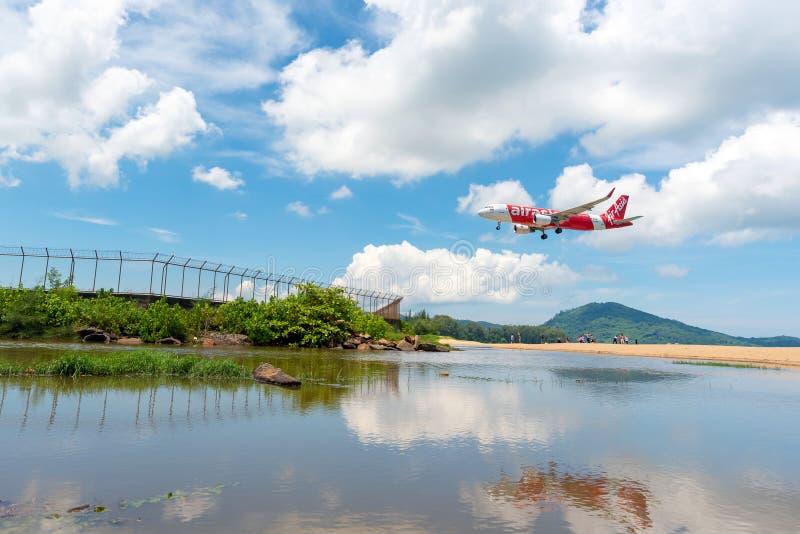 Unidentified tourists at Mai Khao beach with commercial aircraft landing at Phuket International Airport