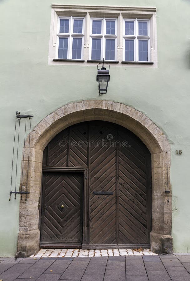 Unique beautiful home entrance with lamp and round wooden brown door in Rothenburg ob der Tauber, Germany. Unique beautiful home entrance with lamp and round wooden brown door in Rothenburg ob der Tauber, Germany