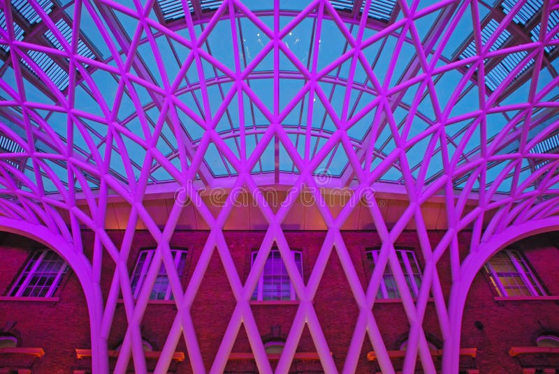 Unik struktur på folkhop av den London konungen Cross Railway Station mot tegelstenbruntbyggnaden Unik struktur på folkhop av den London konungen Cross Railway Station mot tegelstenbruntbyggnaden