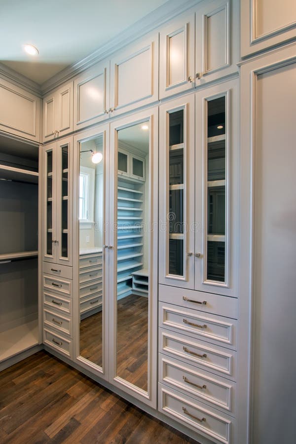 Stylish luxury home walk in closet with plenty of shelves, hangers, mirrors, and drawers. Stylish luxury home walk in closet with plenty of shelves, hangers, mirrors, and drawers.