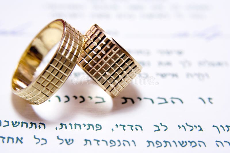 Two wedding rings lean on each other above sentence means This is a union between us in Hebrew. Two wedding rings lean on each other above sentence means This is a union between us in Hebrew