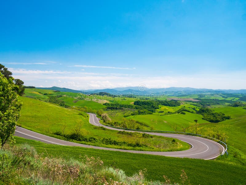 Unique green landscape in Volterra Valley, Tuscany, Italy. Scenic dramatic sky and sunset light over cultivated hill range and