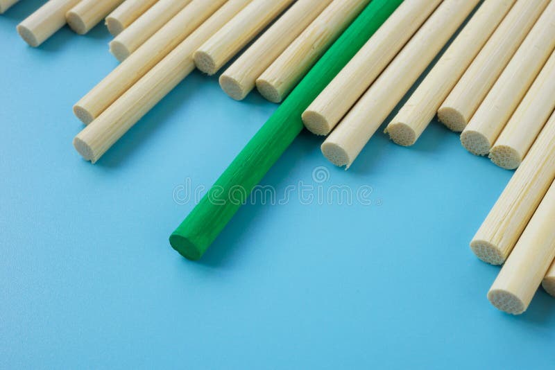 A unique green stick among abstract wooden ones. royalty free stock image