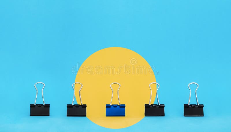 Unique, leadership, individuality, and think different concept. Office supplies, blue binder paper clip stand out of other clips stock photography Unique, leadership, individuality, and think different concept. Office supplies, blue binder paper clip stand out of other clips stock photography