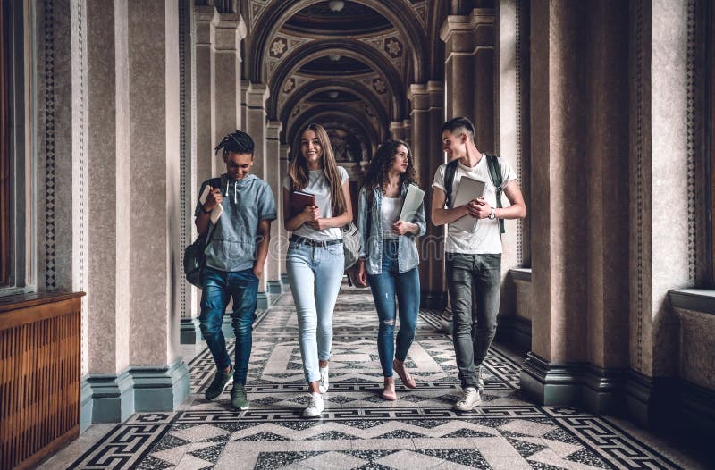 Universitetsområdeliv är enormt! Gruppen av studenter går, i korridor och att prata för universitet royaltyfria foton Universitetsområdeliv är enormt! Gruppen av studenter går, i korridor och att prata för universitet royaltyfria foton