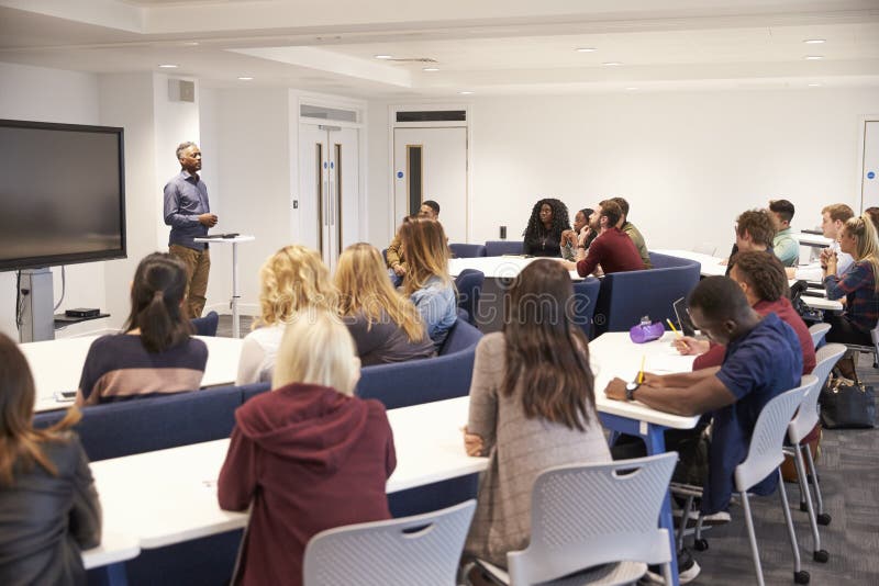 University students study in a classroom with male lecturer royalty free stock image