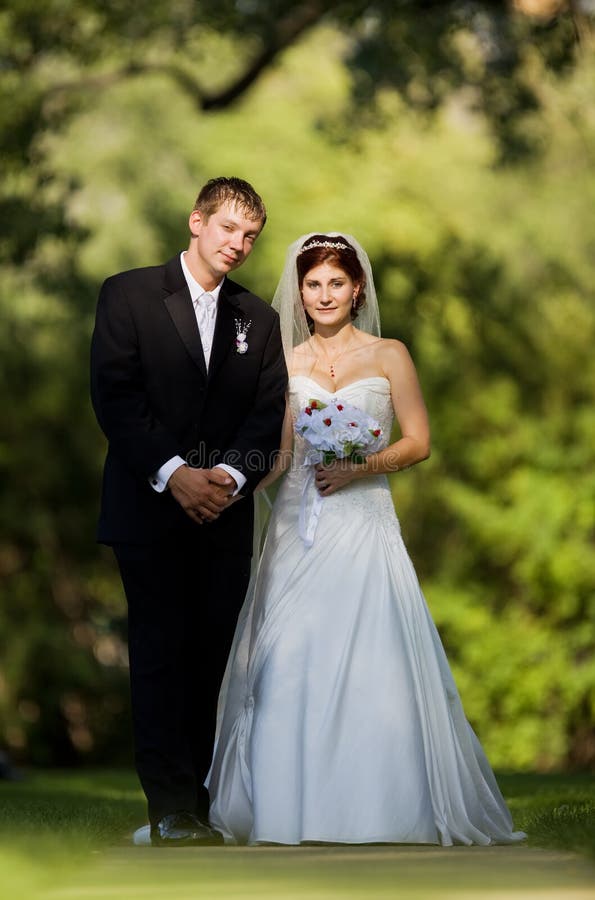 A happy couple just married on a pathway in a park. A happy couple just married on a pathway in a park