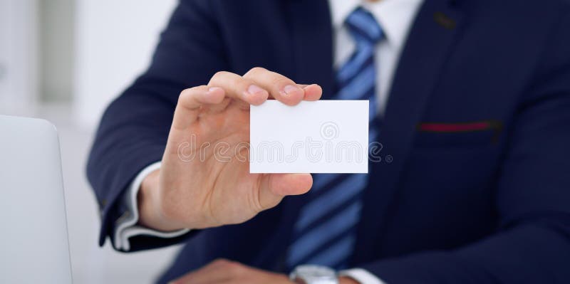 Unknown businessman or lawyer giving a business card while sitting at the table, close-up. He offering partnership an royalty free stock images Unknown businessman or lawyer giving a business card while sitting at the table, close-up. He offering partnership an royalty free stock images