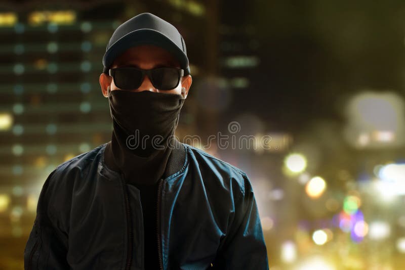 Unknown hacker standing on city background stock images Unknown hacker standing on city background stock images