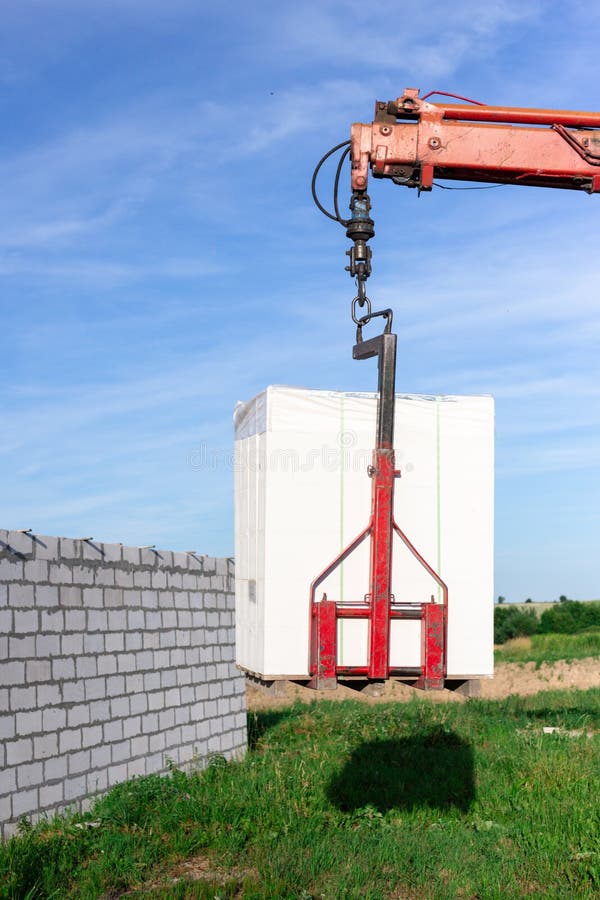 Unloading Building Blocks from a Truck Using a Crane. Hydraulic