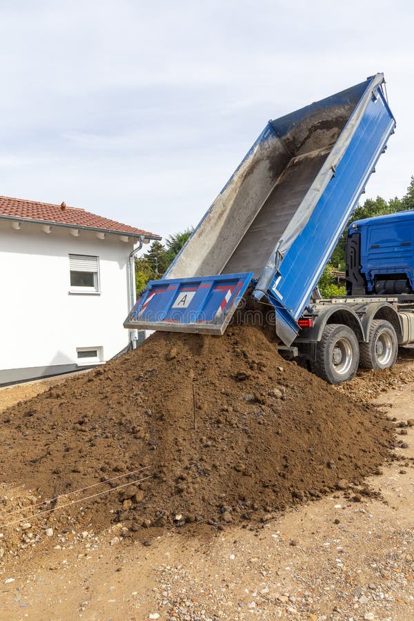Unloading the Truck with Potting Soil from the Truck Bed at the Construction Site Stock Photo