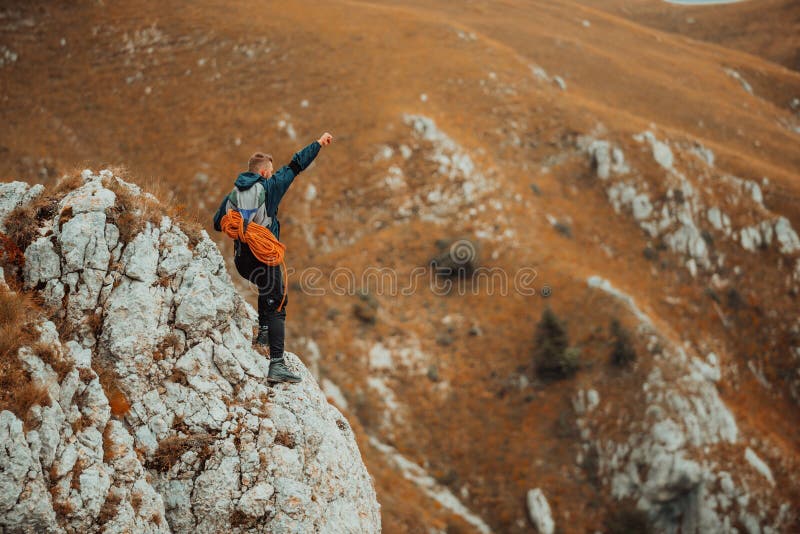 Uno scalatore maschio in alto per celebrare il successo della strada sulla cima della montagna per avventura.. fotografie stock libere da diritti