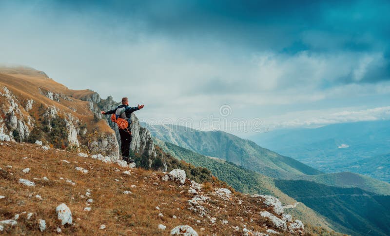 Uno scalatore maschio con le braccia alzate per celebrare il successo del percorso completo durante il viaggio per l'avventura sul immagini stock