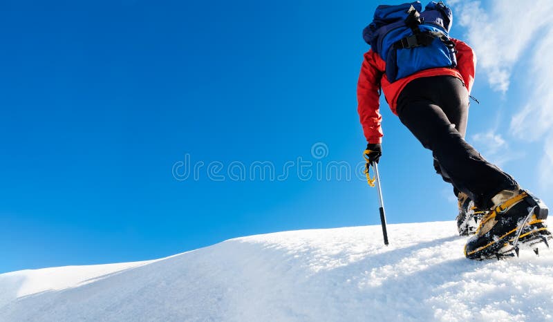 Uno scalatore raggiunge la cima di una montagna nevosa Concetto: coraggio, successo, perseveranza, sforzo, auto-realizzazione