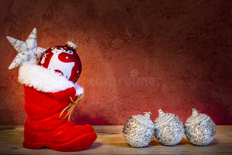 Uno stivale rosso di Santa Claus con la stella di Natale e quattro palle di Natale immagine stock libera da diritti Uno stivale rosso di Santa Claus con la stella di Natale e quattro palle di Natale immagine stock libera da diritti
