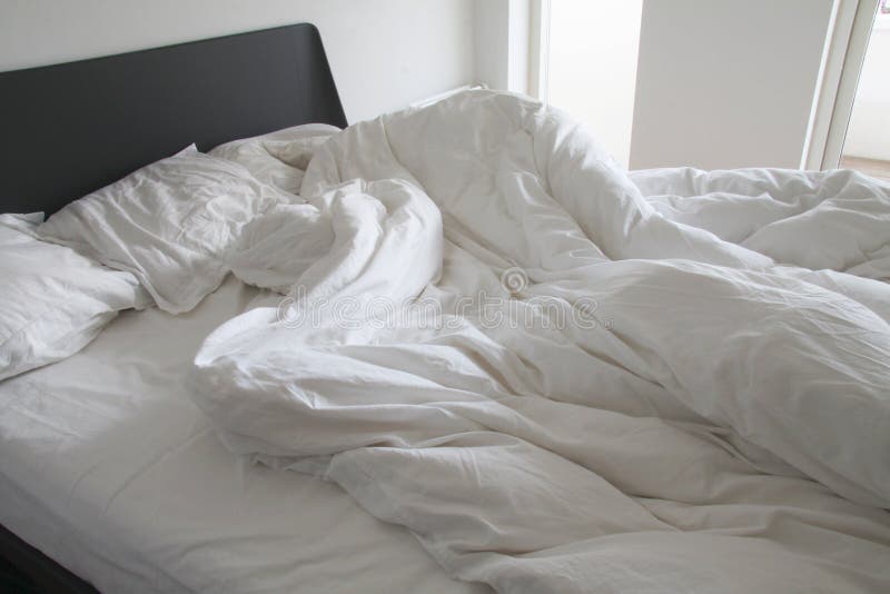 Unordentliche weiße Bettwäscheblätter und -kissen mit Falten auf Bett in einem weißen Schlafzimmer - Vorrat stockbilder Unordentliche weiße Bettwäscheblätter und -kissen mit Falten auf Bett in einem weißen Schlafzimmer - Vorrat stockbilder