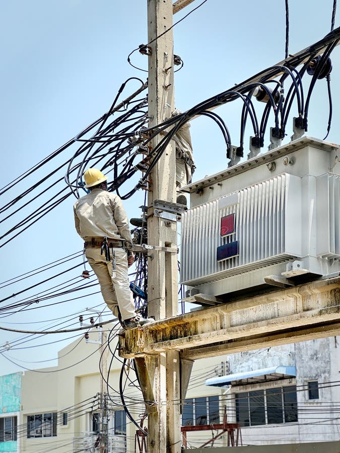 An Unrecognizable Electrician Working Near the High Voltage Transformer