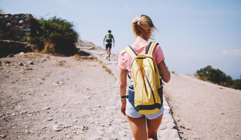 Unrecognizable female tourist walking along footpath stock images