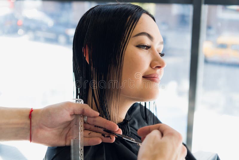 Unrecognizable hairdresser creating hairstyle for beautiful brunette woman stock image Unrecognizable hairdresser creating hairstyle for beautiful brunette woman stock image