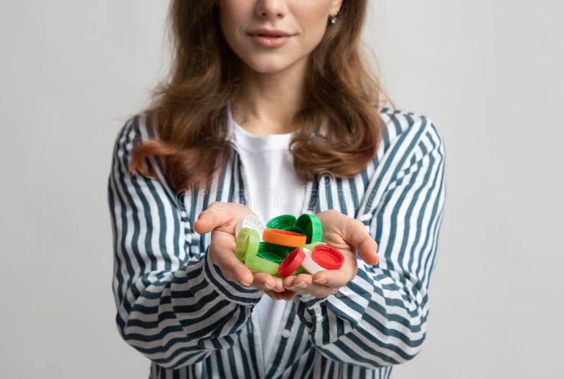 Unrecognizable Lady Holding Colorful Plastic Lids Bottle Cups In Hands stock image