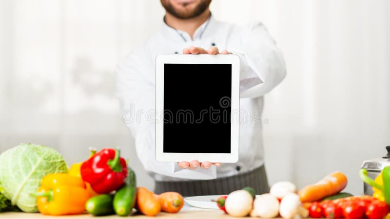 Unrecognizable Male Chef Showing Blank Tablet Screen Standing In Kitchen royalty free stock image
