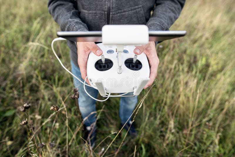 Unrecognizable man with remote control. Sunny green nature. royalty free stock photography