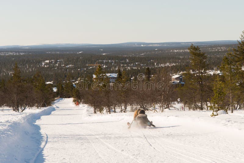 Unrecognizable people sledding down a tobogganing run in Lapland royalty free stock photos