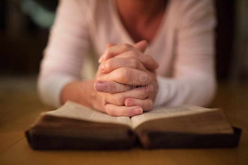 Unrecognizable woman praying, hands clasped together on her Bibl royalty free stock image Unrecognizable woman praying, hands clasped together on her Bibl royalty free stock image