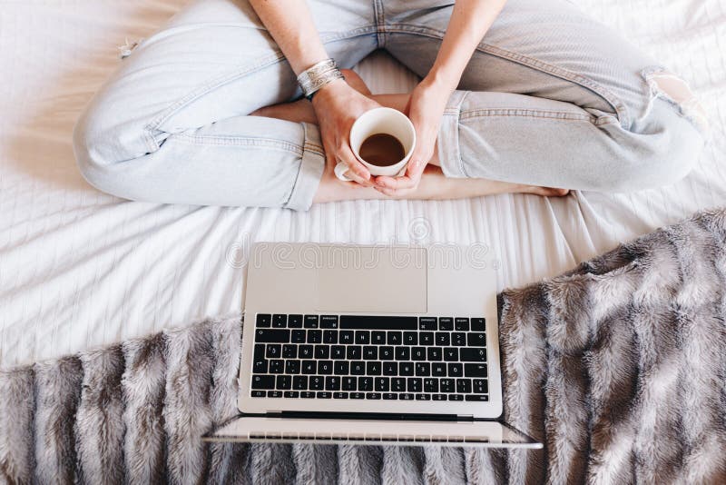 Unrecognized woman drinking coffee and watching a Tv series on her laptop royalty free stock photos Unrecognized woman drinking coffee and watching a Tv series on her laptop royalty free stock photos