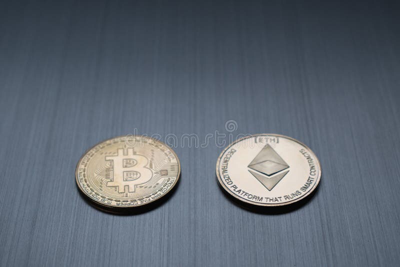Uns bitcoin e ethereum dourados inventam em um fundo metálico C imagens de stock Uns bitcoin e ethereum dourados inventam em um fundo metálico C imagens de stock