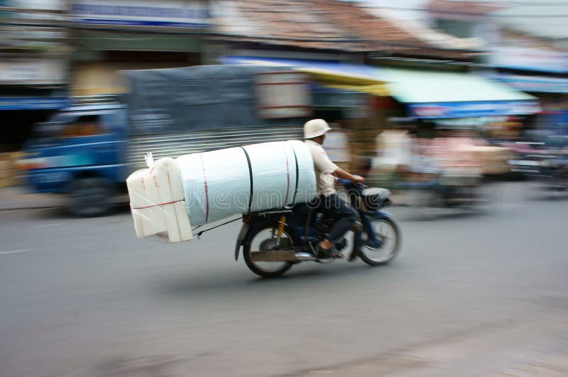 HO CHI MINH, VIET NAM- MAR 30: Unsafe, danger of transportation on Vietnamese street, man ride motorcycle, transport goods in overloaded, voluminous, cause of traffic accident, Vietnam, Mar 30, 2013. HO CHI MINH, VIET NAM- MAR 30: Unsafe, danger of transportation on Vietnamese street, man ride motorcycle, transport goods in overloaded, voluminous, cause of traffic accident, Vietnam, Mar 30, 2013