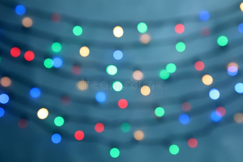 Unscharfe Ansicht von Weihnachtslichtern auf Farbhintergrund stockfoto