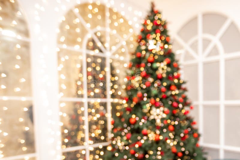 Unscharfer Hintergrund Weihnachtsraum-Inneres mit Neujahrsbaum und Geschenklichter in Rot-, Grün-Farben lizenzfreies stockbild